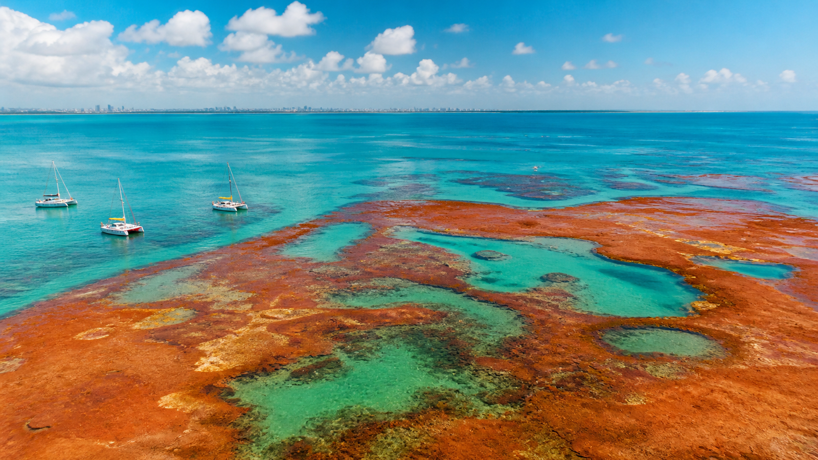 João Pessoa Beyond the Obvious: 6 Quiet Beaches and Peaceful Escapes 2 Low-tide reddish sandbar surrounded by shallow emerald natural pools at Areia Vermelha in Cabedelo, Brazil.
