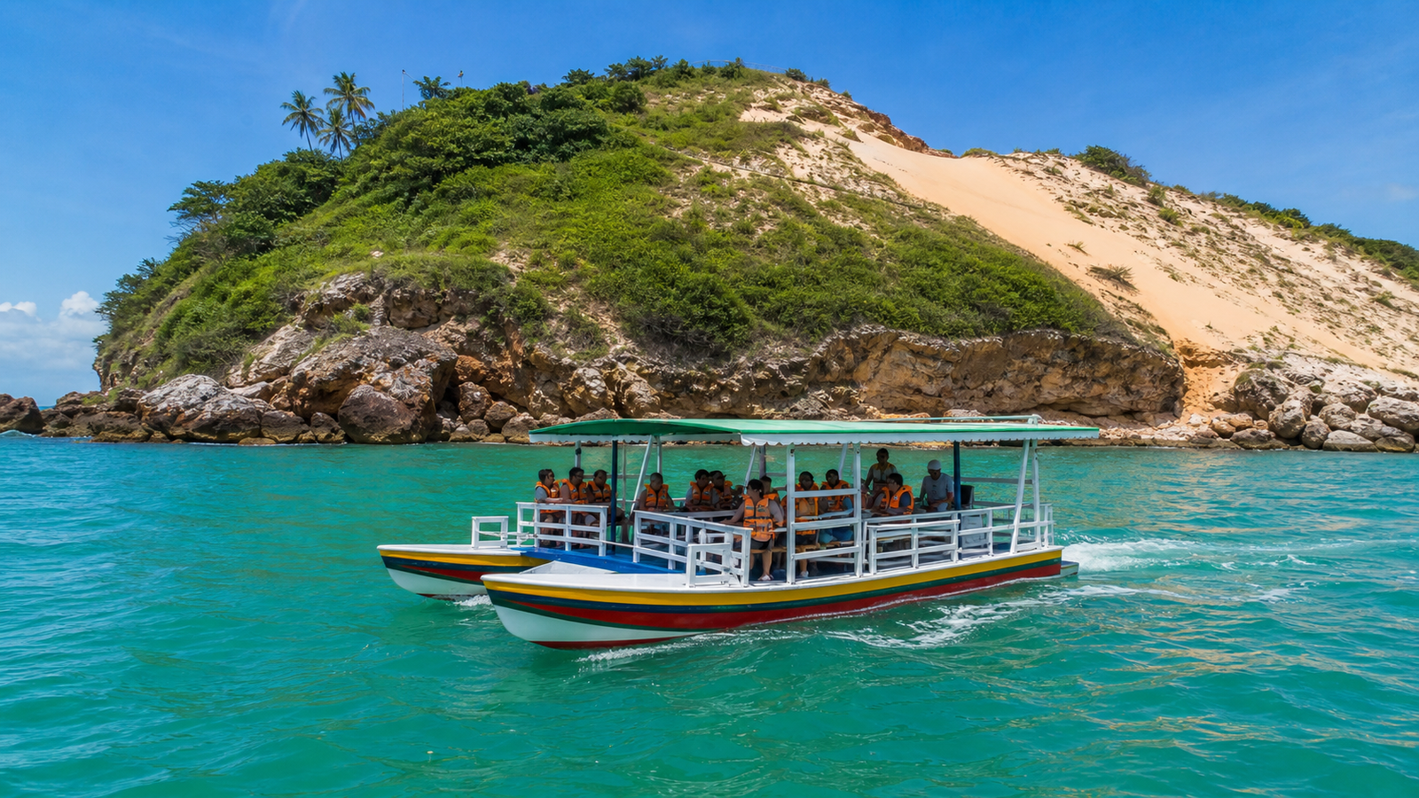 Morro do Careca in Natal: How to Visit Without Wasting Time or Money 2 A traditional Jangalancha boat cruising on emerald ocean waters near Morro do Careca in Natal.