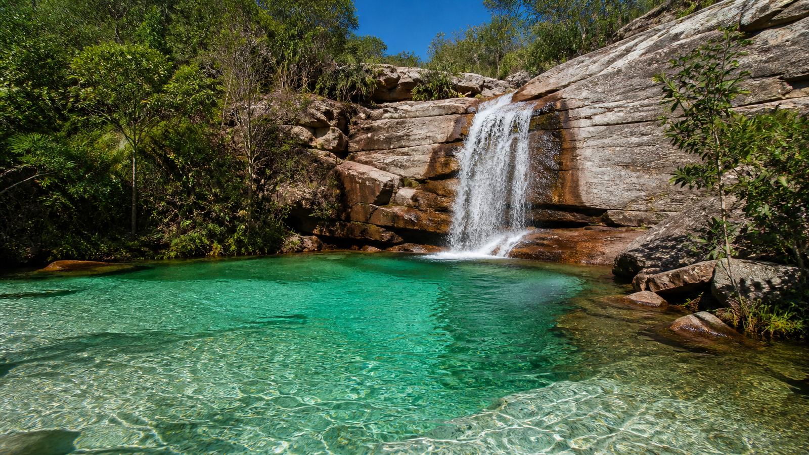 Crystalline turquoise waterfall plunge pool in the Cerrado near Pirenópolis, Goiás.