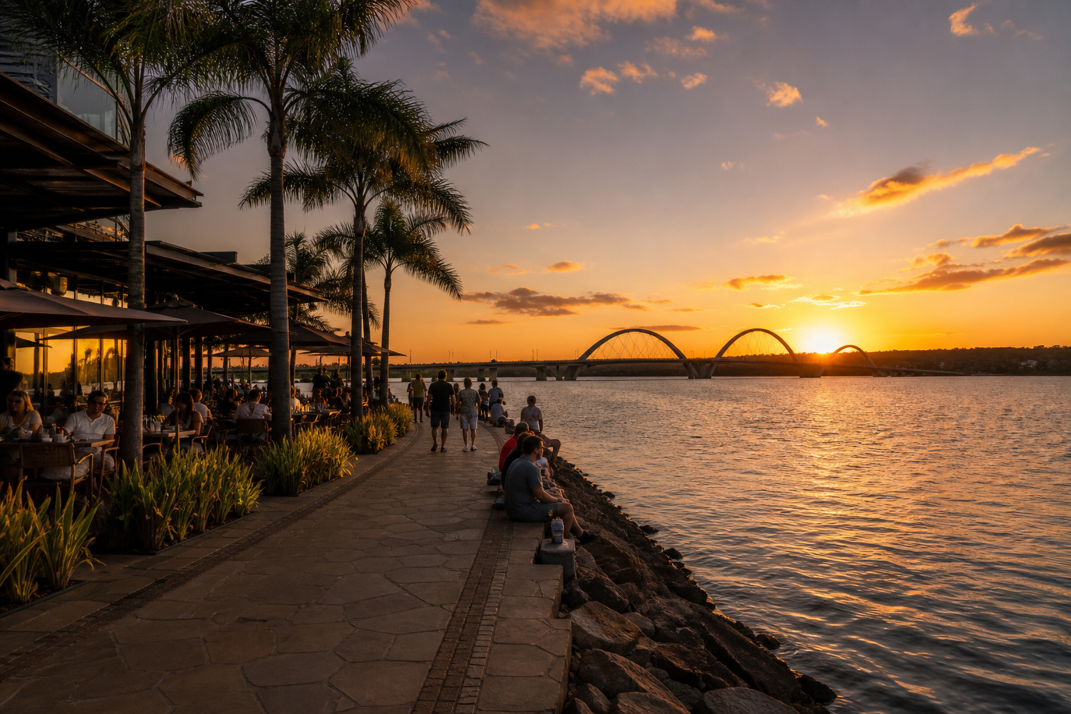 Sunset over Lake Paranoá at Pontão do Lago Sul with waterfront promenade, palm trees, and Ponte JK in the background