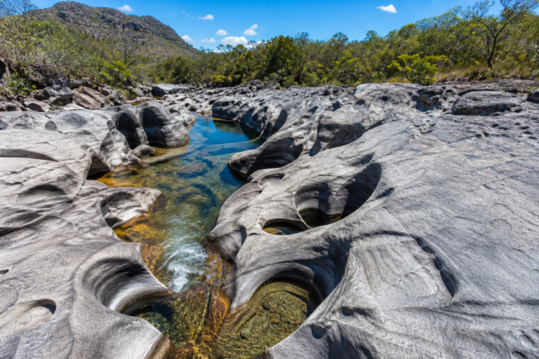 Sculpted grey rock formations and clear natural swimming pools at Vale da Lua in Chapada dos Veadeiros, Brazil