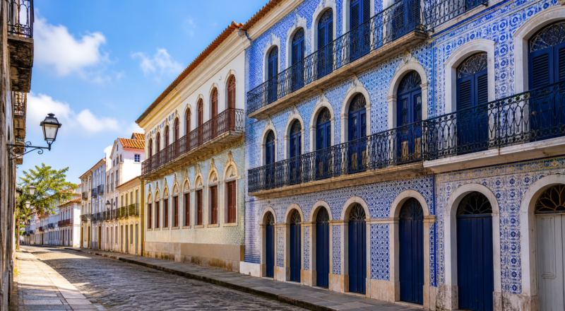 Historic cobblestone street in São Luís Maranhão lined with colonial Portuguese tile-covered mansions under morning sunlight.