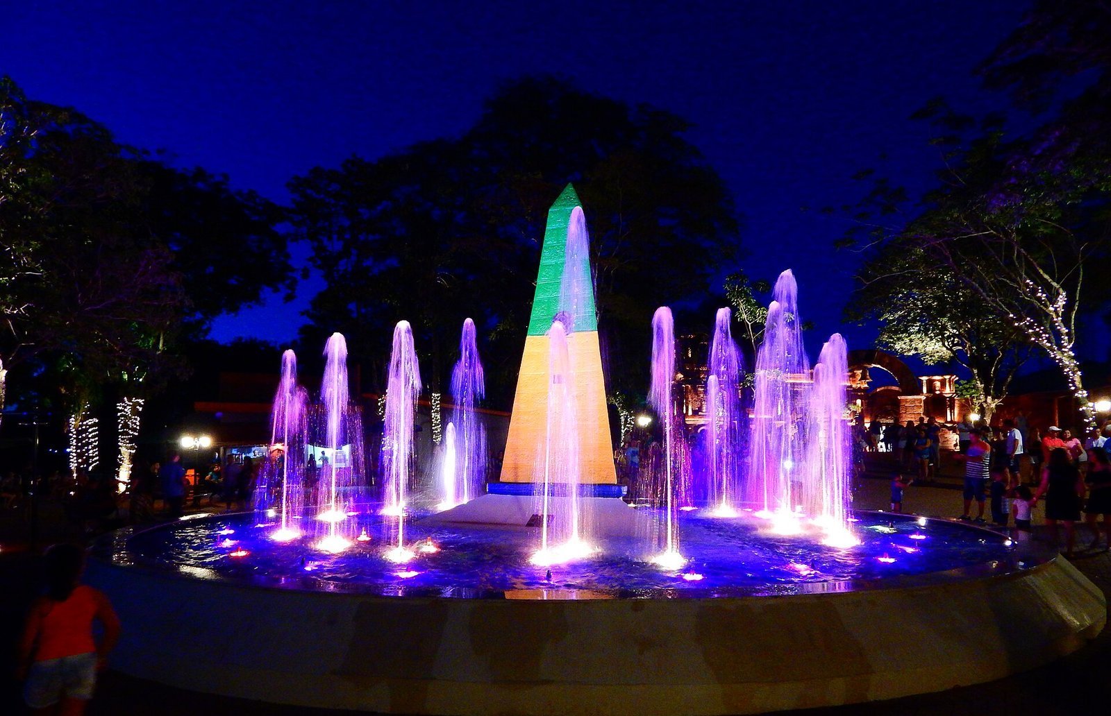 Triple Frontier Landmark obelisk lit at night with colorful fountains