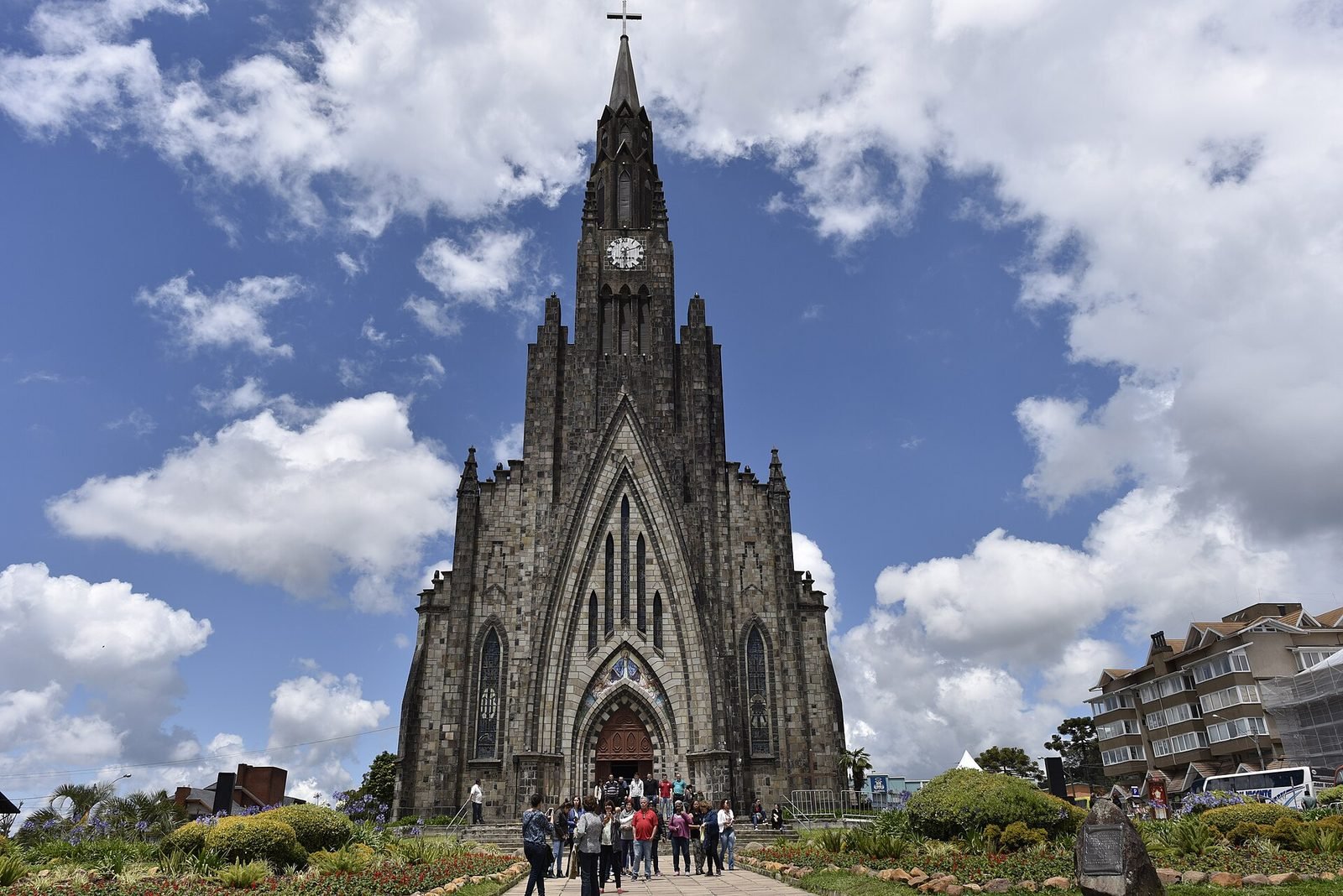 The Stone Cathedral in Canela, a neo-Gothic stone church with a tall tower and flower gardens in front