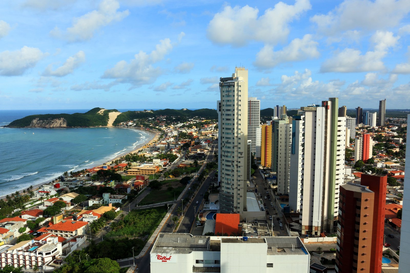 Natal Brazil Travel Guide 2026: Things to Do, Prices, Itineraries and Where to Stay 2 Aerial view of Ponta Negra beach in Natal, Brazil, with the sand, the beachfront buildings and the vegetated Morro do Careca dune at the end of the beach