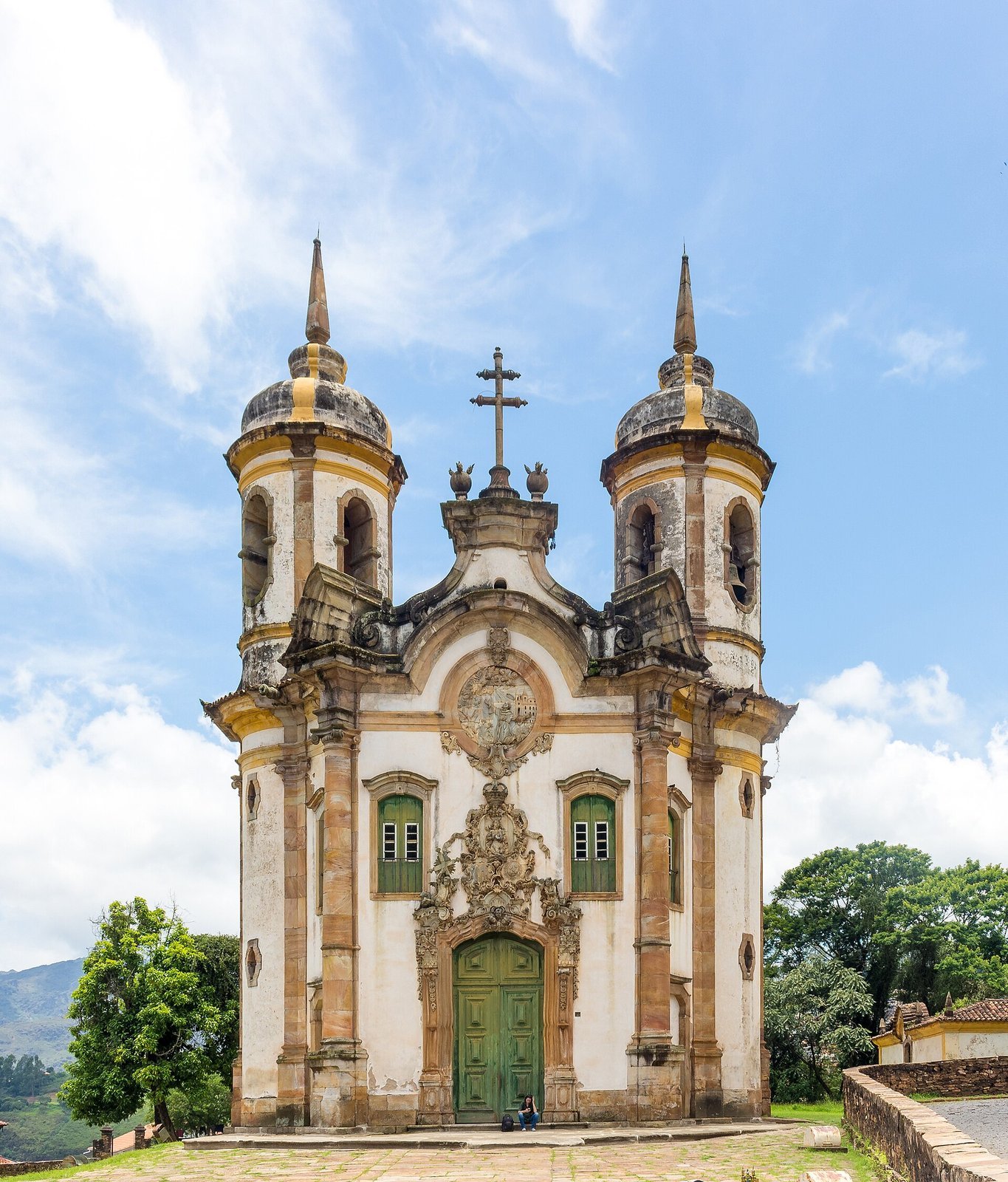 O que fazer em Ouro Preto: guia completo 2026 com história, igrejas, minas, preços, roteiro e onde ficar 4 Fachada da Igreja de São Francisco de Assis em Ouro Preto, com duas torres redondas, portada esculpida em pedra-sabão e céu azul